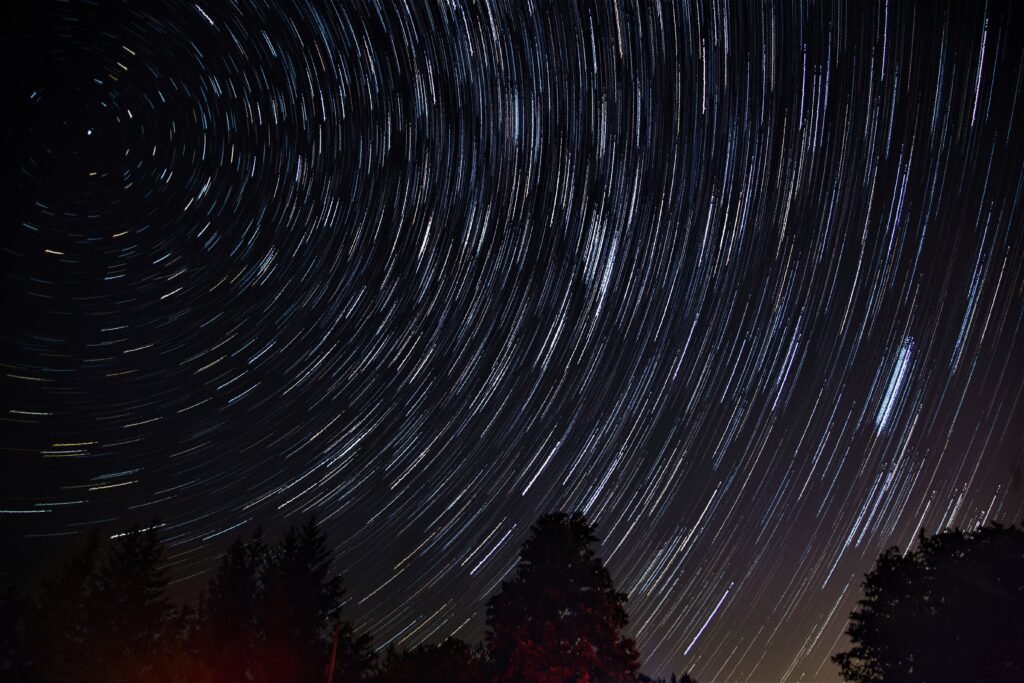 Bela foto do céu noturno com estrelas giratórias usando a técnica de astrofotografia trilhas de estrelas ou star trails. 