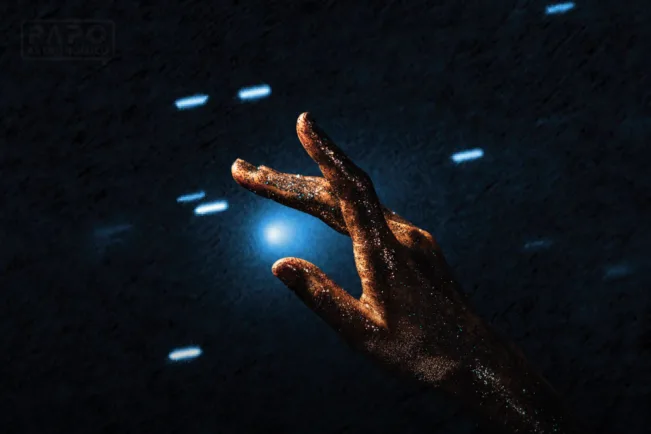 Imagem artística de uma mão coberta de poeira dourada apontando para um cometa brilhante no céu escuro, ilustrando a atenção da NASA ao objeto 3I/ATLAS.