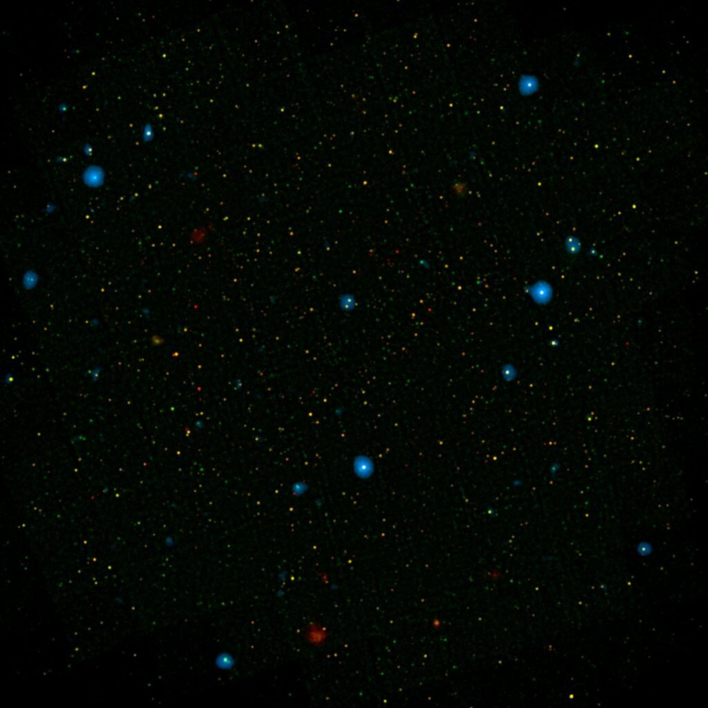 Os pontos azuis neste campo de galáxias, conhecido como campo COSMOS, mostram galáxias que contêm buracos negros supermassivos emitindo raios X de alta energia. Os buracos negros foram detectados pelo NuSTAR (Nuclear Spectroscopic Array) da NASA, que identificou 32 desses buracos negros neste campo e já observou centenas em todo o céu.