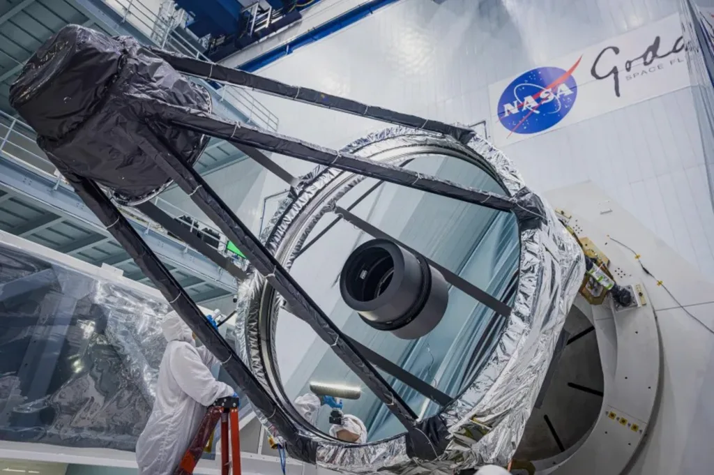 Um engenheiro óptico inspeciona o espelho primário do telescópio espacial Roman da NASA logo após ele ter sido retirado do contêiner de transporte.