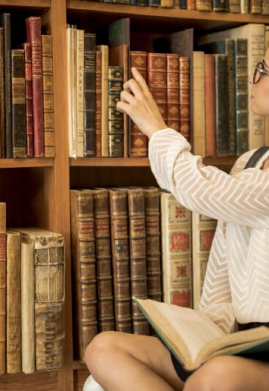 Imagem de <a href="https://br.freepik.com/fotos-gratis/aluna-sentando-cross-legged-com-livro-aberto-em-biblioteca_4912291.htm#fromView=search&page=5&position=34&uuid=ea140e58-a7df-4297-820e-861cc3135929">Freepik</a>